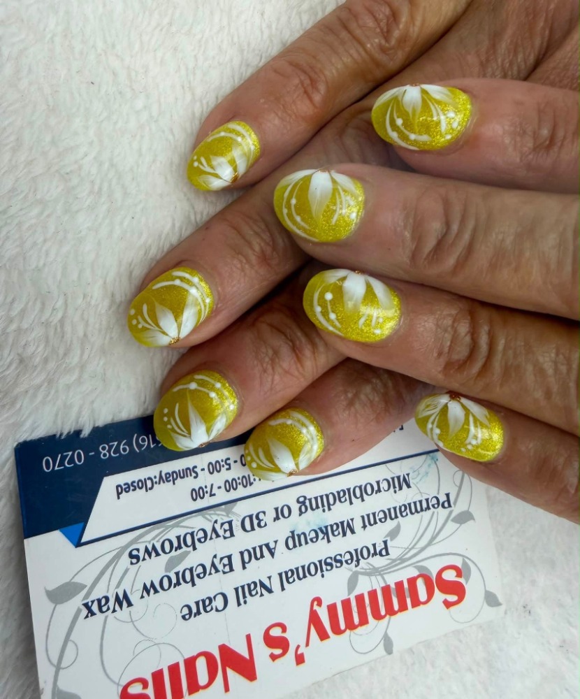 Gold glitter nails with white floral art — Sammy's Nails Holland MI